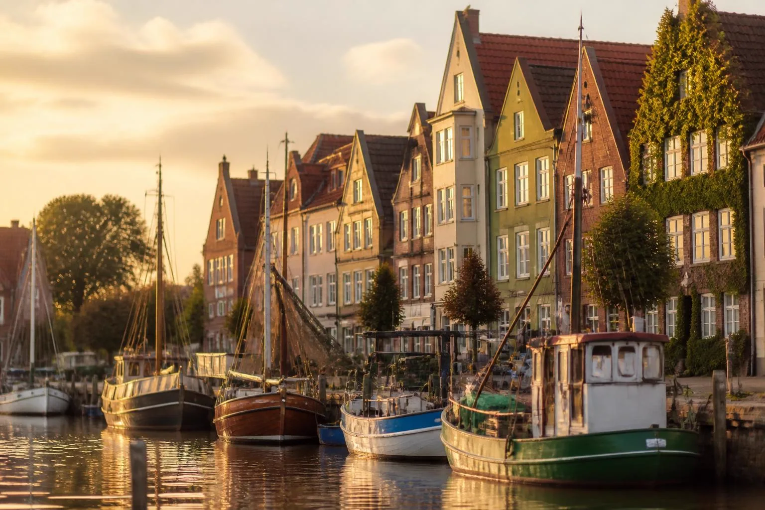 Kleiner Binnenhafen mit Kuttern und bunten Giebelhäusern am Kai