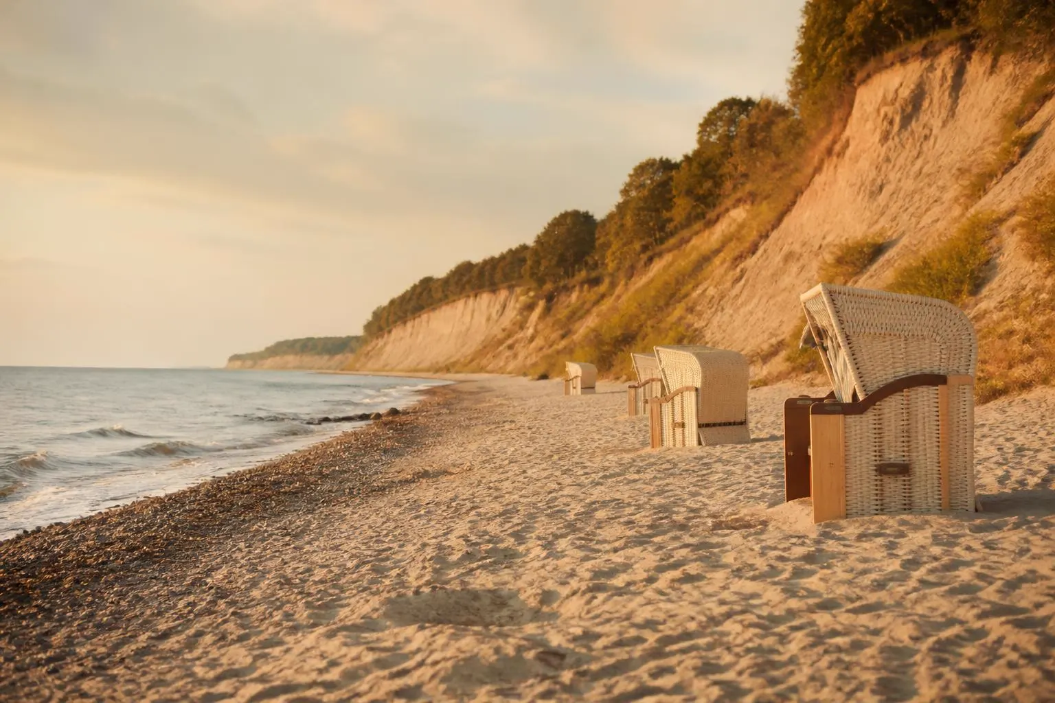 Ostseestrand mit Steilküste und einigen Strandkörben im Sand