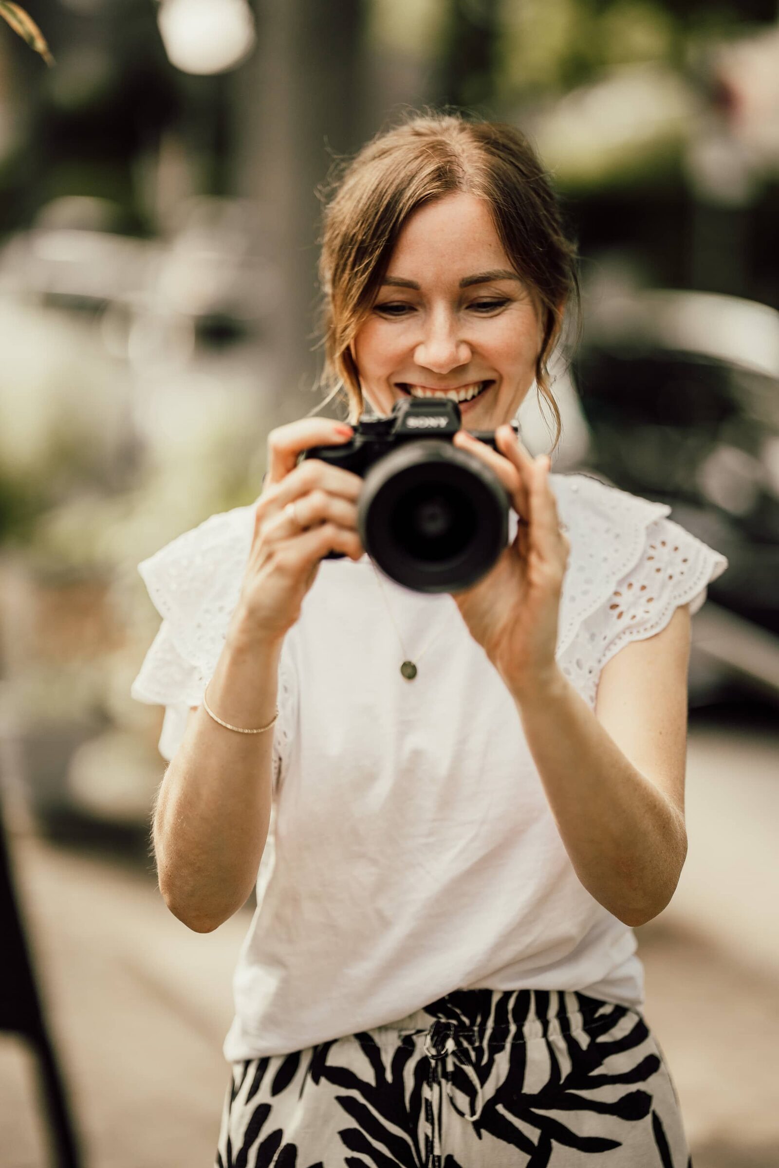 Charlyn Can fotografiert lachend mit der Kamera vor dem Gesicht